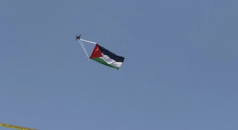 Raised by "Dron" .. the flag of Palestine flutters over the settlers' march