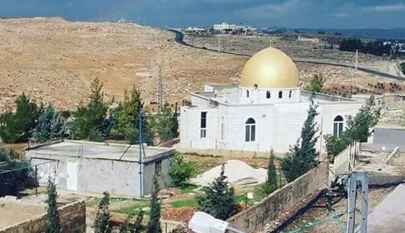Settlers raise Israeli flags over a mosque
